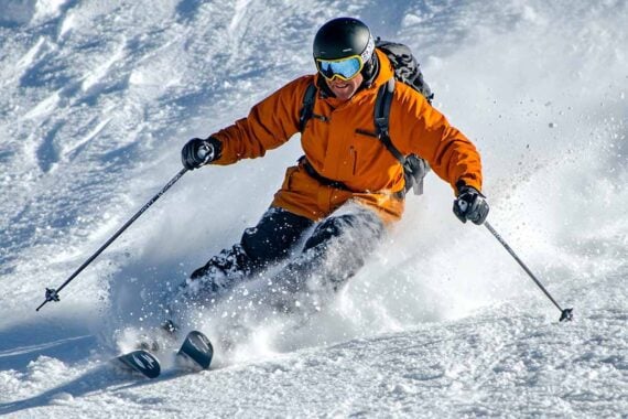 Photo of a man snow skiing downhill.