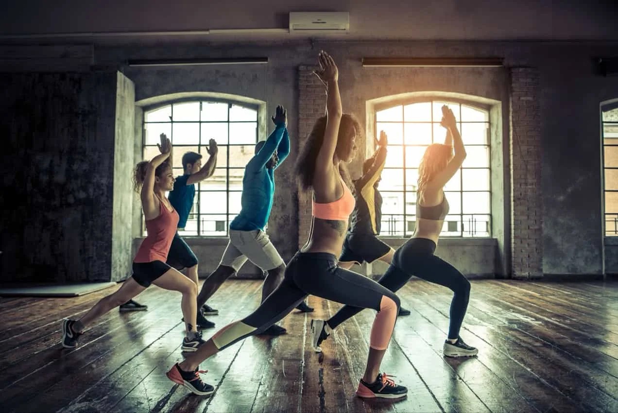 Group of people in yoga studio with natural light.