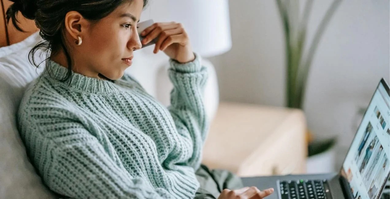 woman scrolling through product photos on a laptop