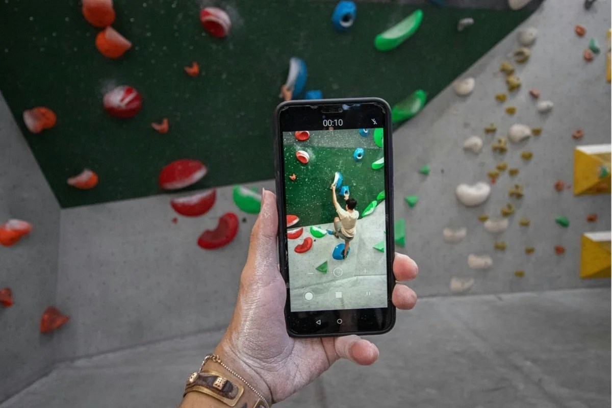 someone recording a video of another person rock climbing