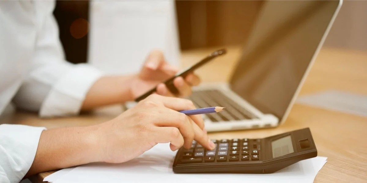 someone working on a computer with a calculator