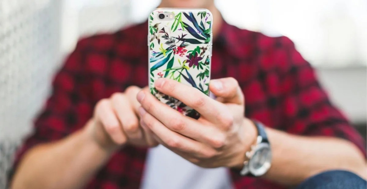 man using a phone with a floral pattern