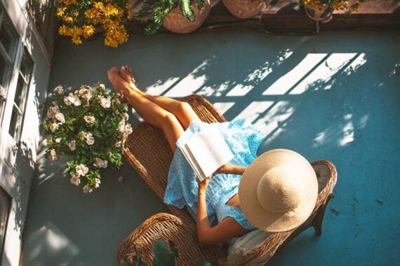 Photo of a female in an outdoor patio reading a book Photo of a female in an outdoor patio reading a book