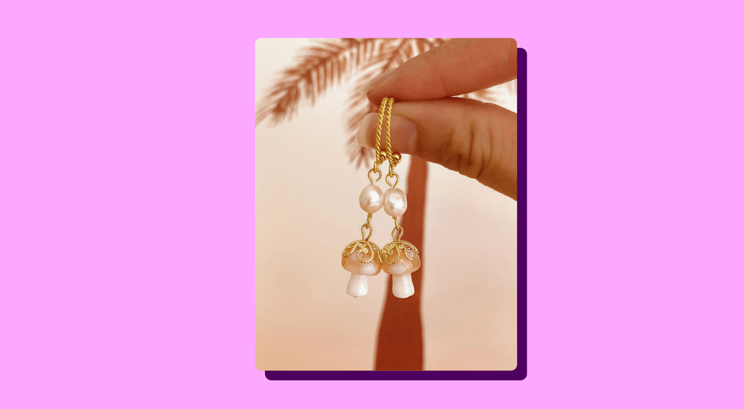 a photo of a pair of mushroom-shaped pearl earrings on a pink background