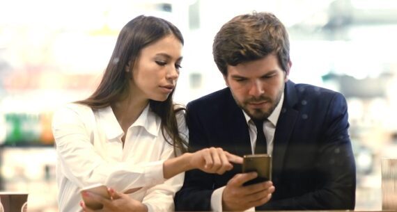 Female and male looking at a smartphone